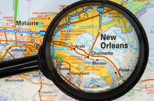  Photo of map and a magnifying glass pointing to New Orleans 