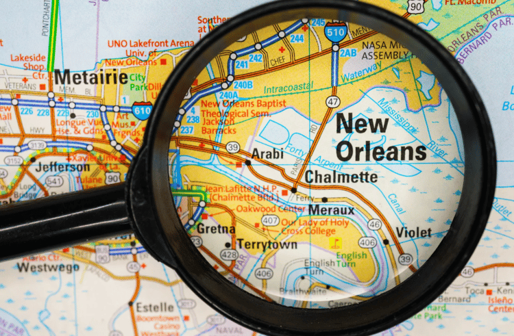  Photo of map and a magnifying glass pointing to New Orleans 